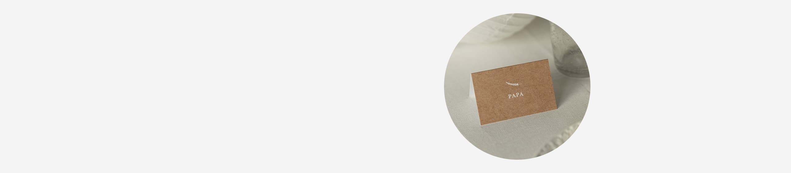 Nahaufnahme einer Tischkarte, schlichtes Design, mit Text "Papa", aufgestellt auf einem gedeckten Tisch